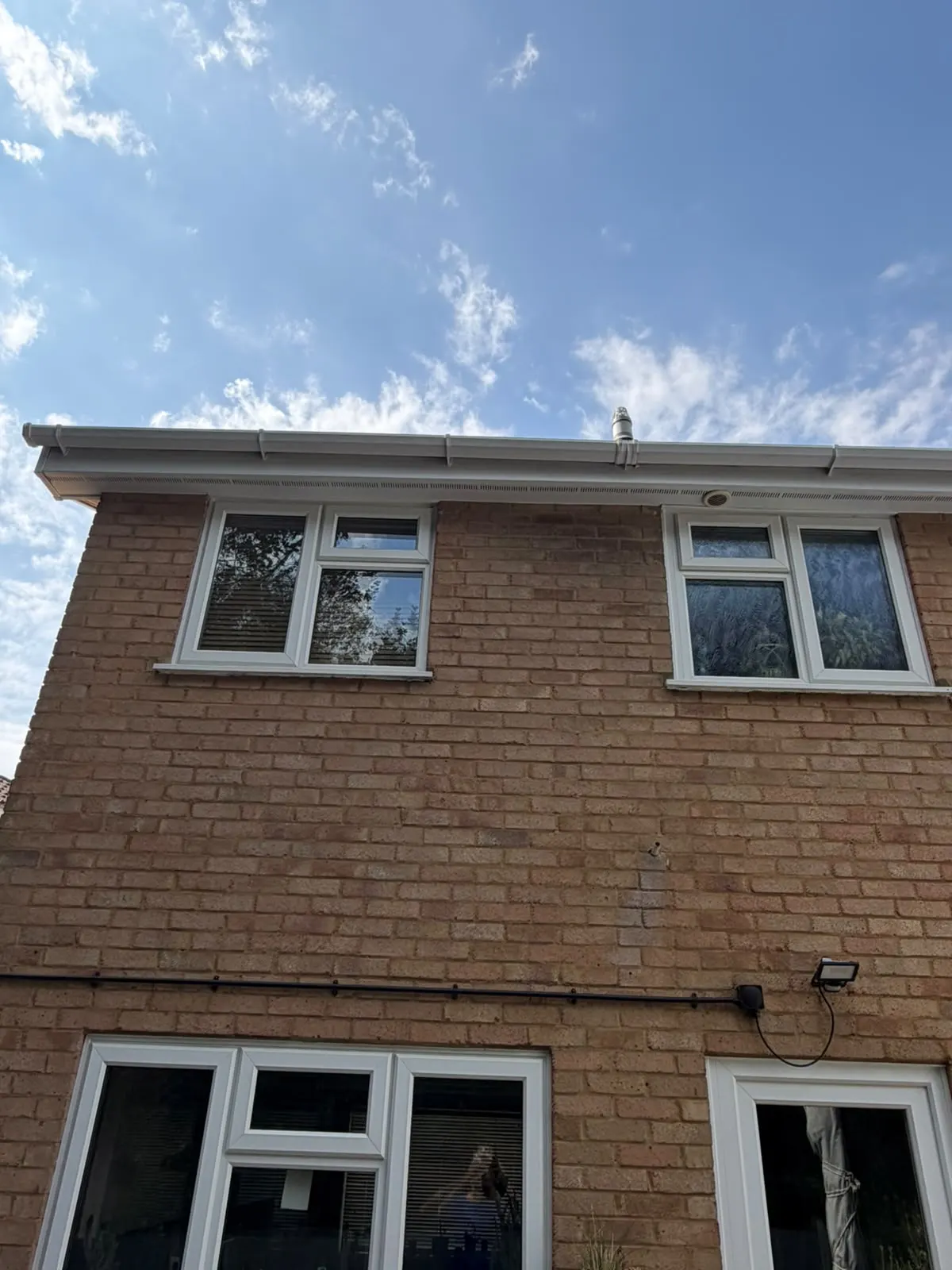 The same white uPVC gutter, fascia and soffit after cleaning, bright and clear