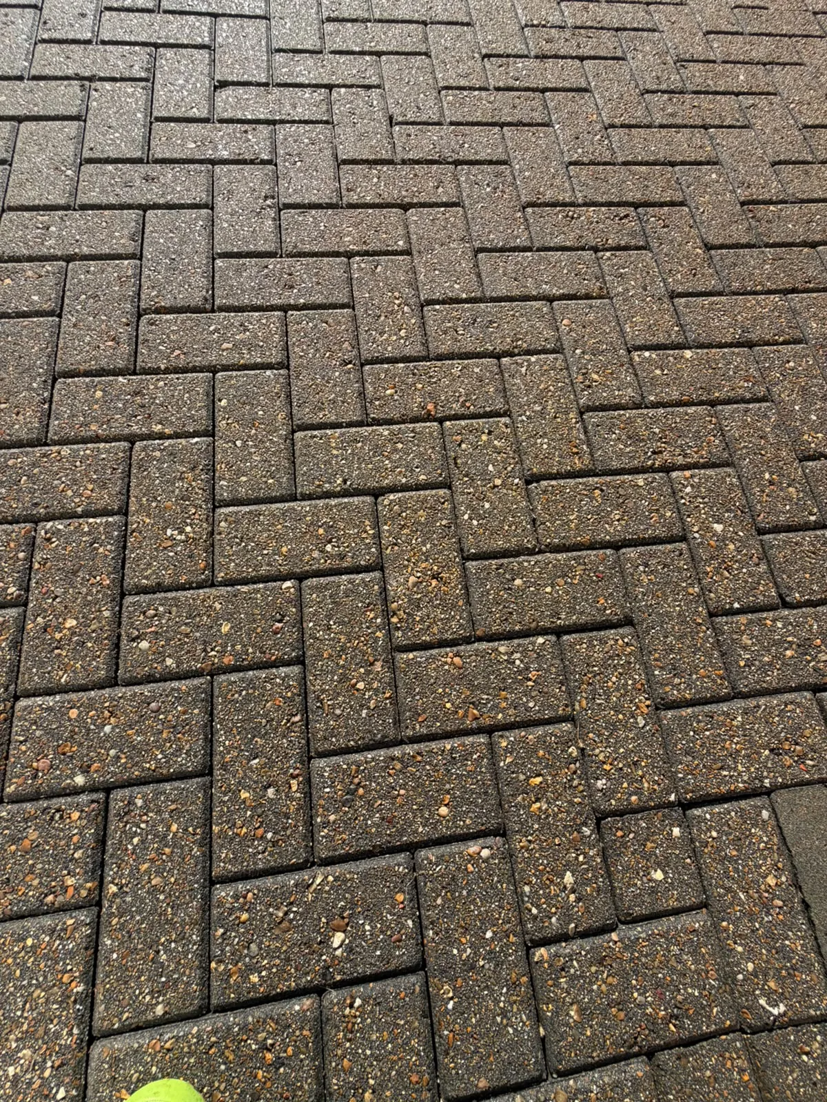 Matching herringbone driveway close-up after cleaning, showing the cleaning stage rather than completed re-sanding